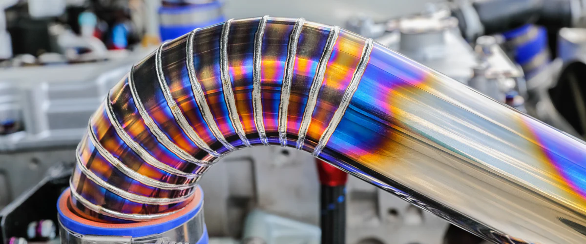 Mastering Titanium TIG Welding: The Ultimate Guide to Settings, Techniques, and Best Practices 1 Professional TIG welding of titanium exhaust with perfect gas shielding and silver weld bead.