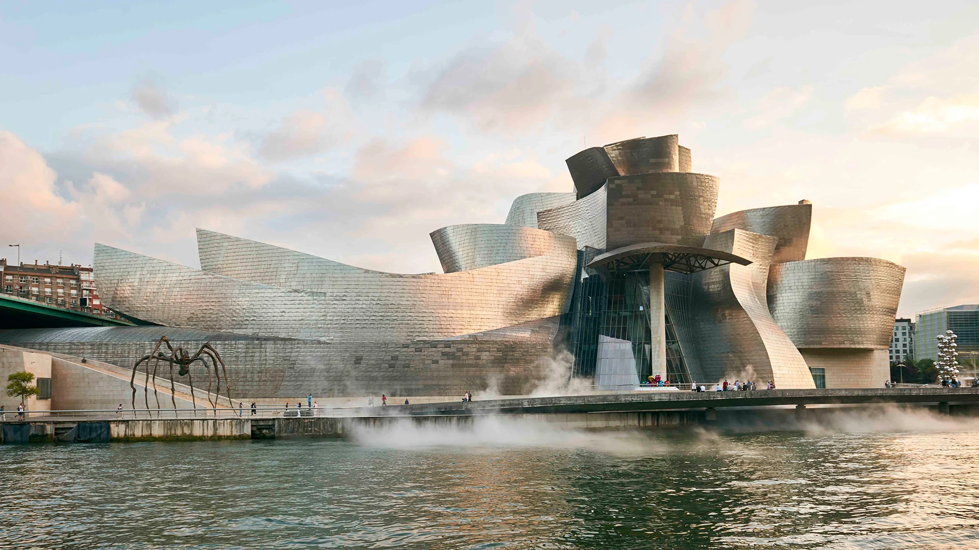 Guggenheim Museum Bilbao exterior showing curved titanium panel facade reflecting light - Frank Gehry 1997 landmark