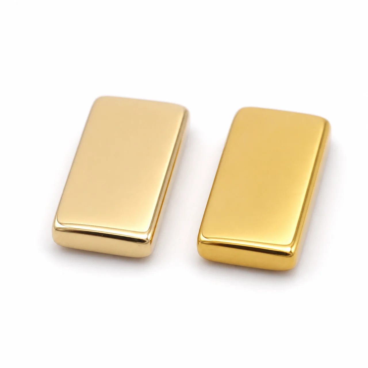 Two gold-finished titanium metal samples side by side - PVD TiN gold finish vs electroplated gold comparison showing color and surface difference